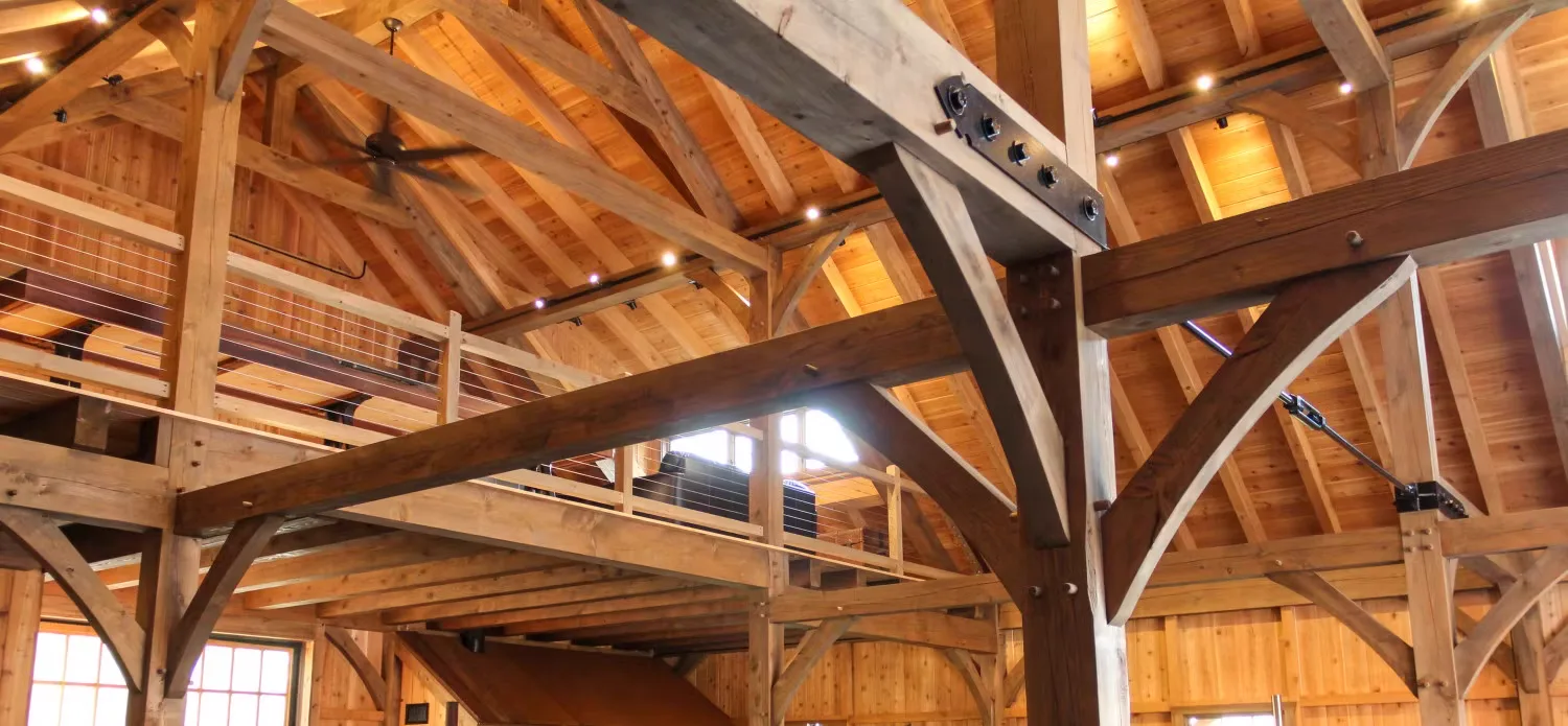 Exposed heavy timber framing with bolted beam connections and roof trusses