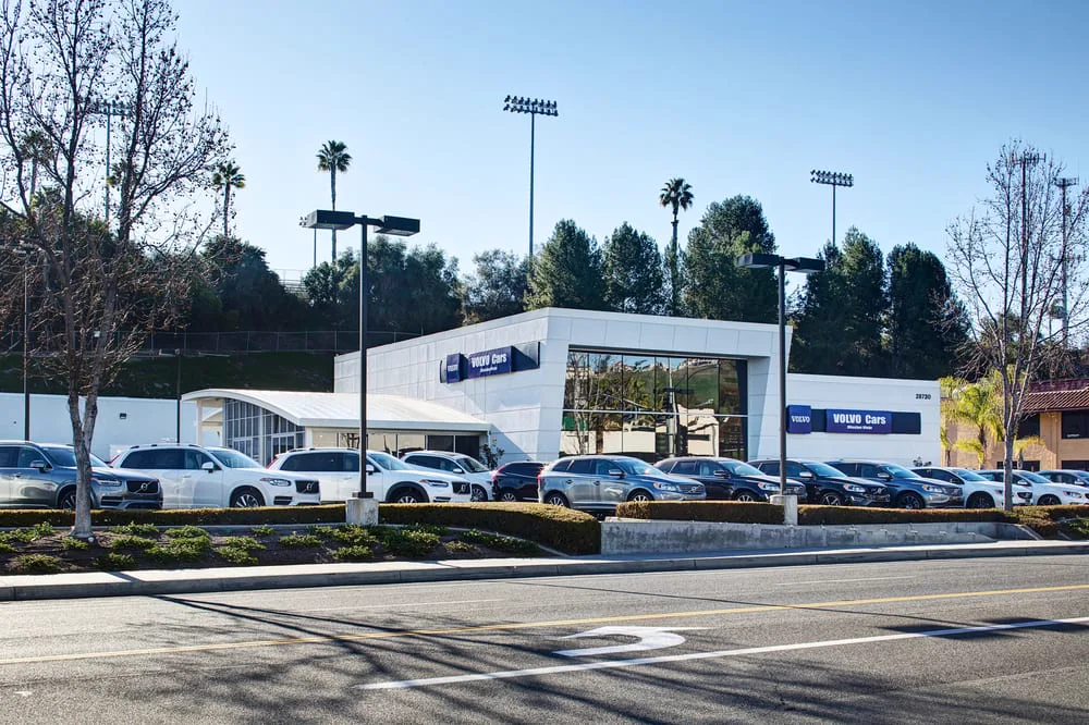 Volvo dealership exterior with cars displayed along the street.